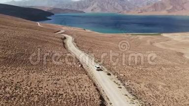 在4x4路的高空，汽车沿着砾石小径驶向干旱山区的湖泊。 帕米尔公路<strong>丝绸之路</strong>